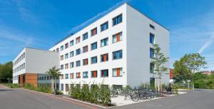 Blick auf das "Ernst-Abbe-Gymnasium" mit Fahrradständern und Grünfläche