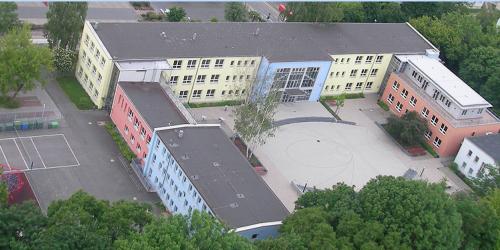 Blick auf das "Carl Zeiss Gymnasium" mit Schulhof und kleiner Sportfläche