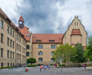 Eckgebäude der Nordschule von außen. Davor Spielen Kinder auf dem Schulhof.