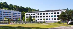 Außenansicht des Sportgymnasiums mit Beachvolleyballplatz und Basketballanlage