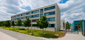 Blick auf das "Otto-Schott-Gymnasium" mit Grünanlage und Schulhof