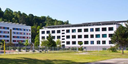 Außenansicht des Sportgymnasiums mit Beachvolleyballplatz und Basketballanlage