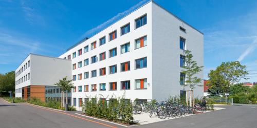 Blick auf das "Ernst-Abbe-Gymnasium" mit Fahrradständern und Grünfläche