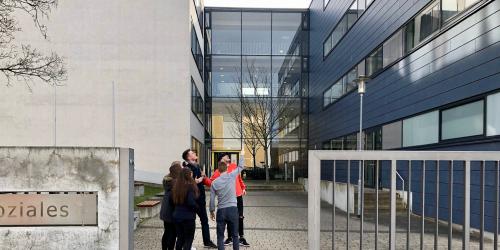 Blick auf den Haupteingang der Berufsbildenden Schule für Gesundheit und Soziales mit Schülergruppe